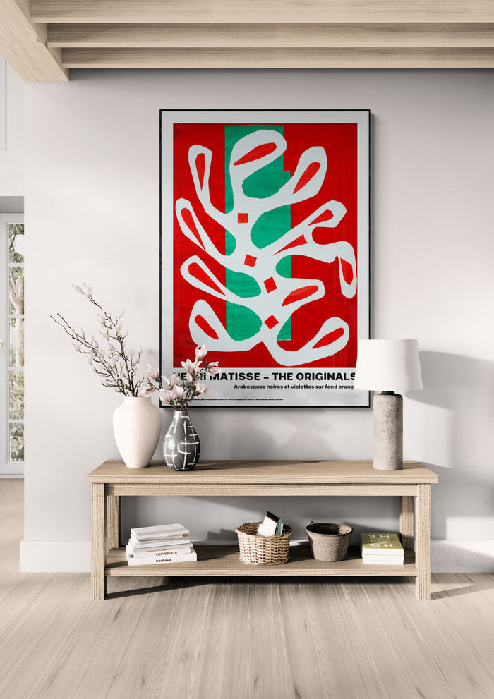 Framed "Arabesques" by Henri Matisse displayed above a wooden console in a modern living room.