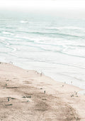 A serene beach scene with gentle waves and people walking along the sandy shore, perfect for coastal decor.