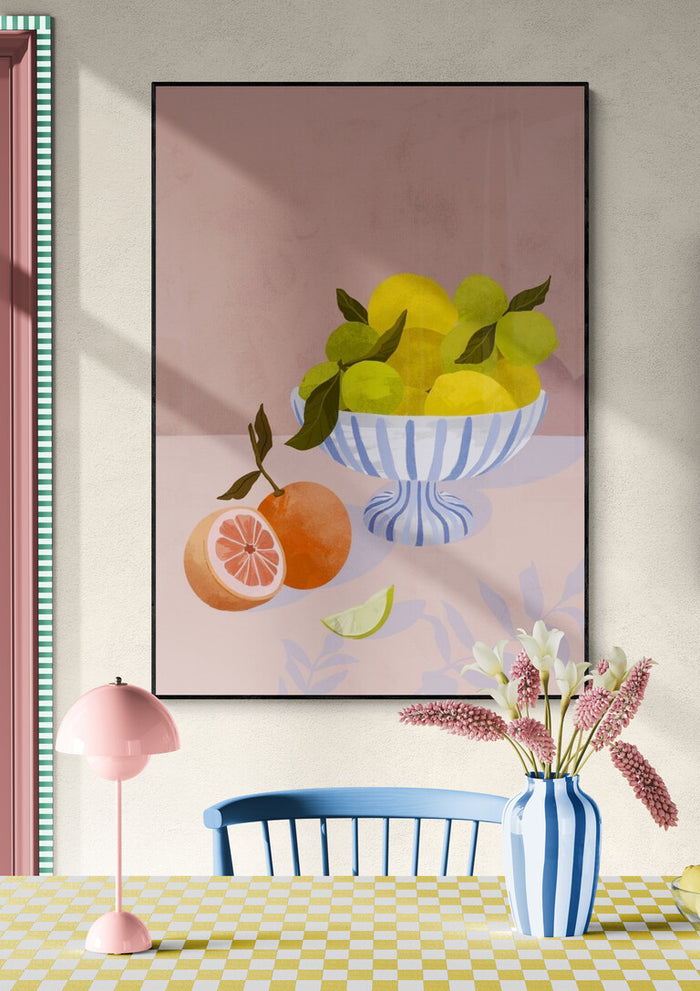 Framed painting of citrus fruits in a striped bowl, styled in a modern dining room with pastel decor.