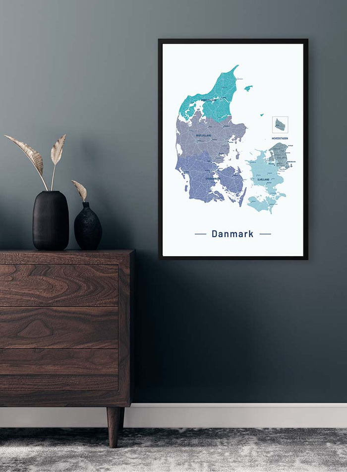 Blå Danmarkskort Plakat displayed on a wall above a wooden dresser in a modern, minimalist room.
