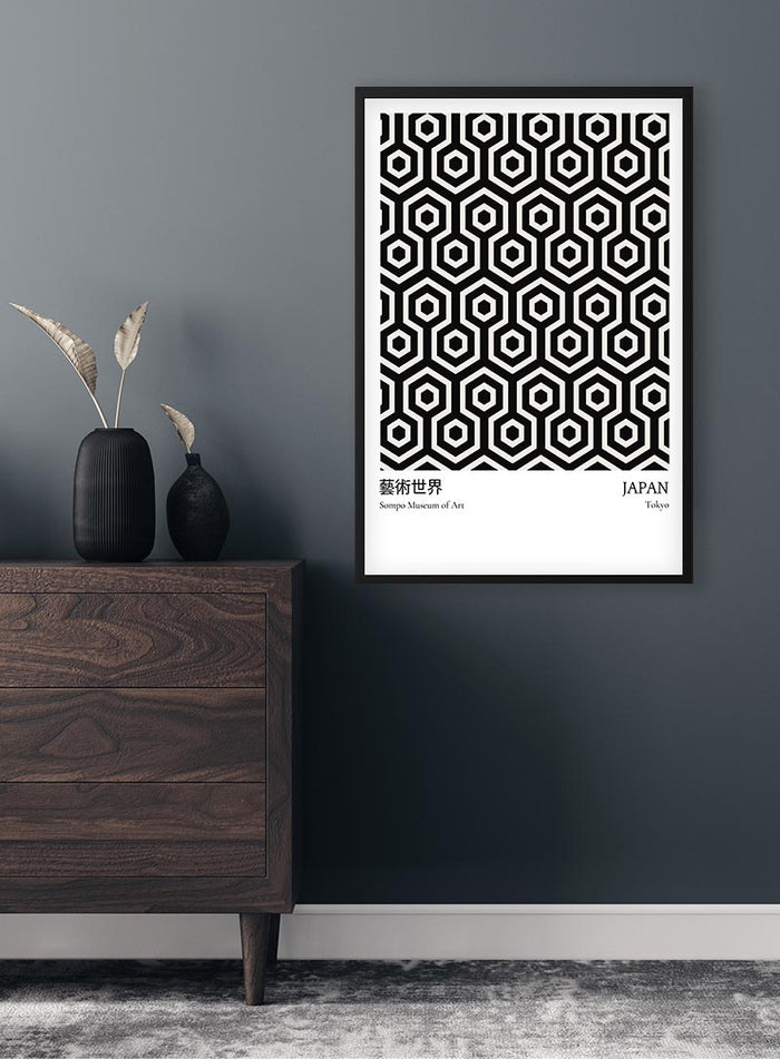 Black from Japan Exhibition Plakat featuring geometric hexagonal patterns, framed and displayed on a dark wall.