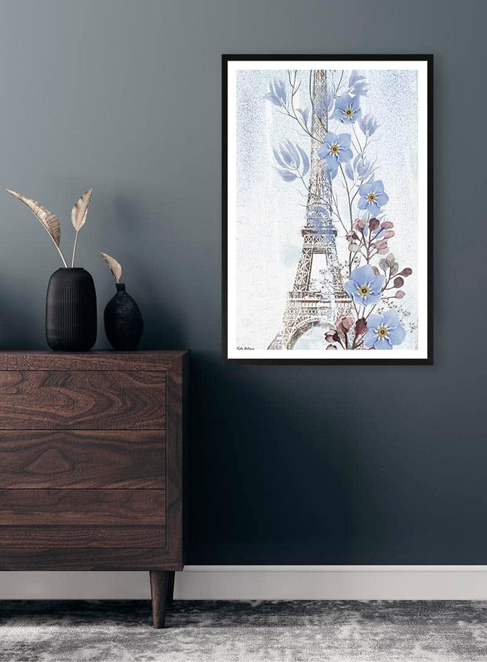 Framed "Blue Paris - Kate Aitana" artwork with blue flowers and Eiffel Tower on a dark wall above a dresser.