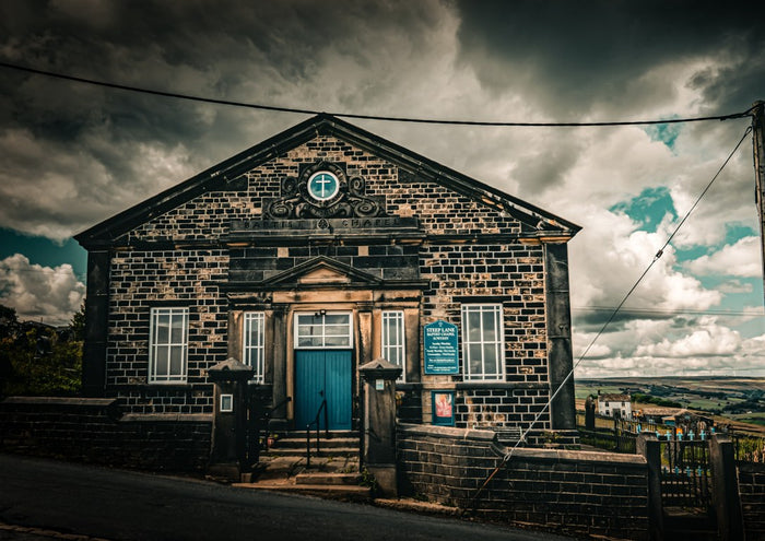 Chapel under Storm Clouds by Northern Gnome Photography - stone chapel with a teal door under grey clouds