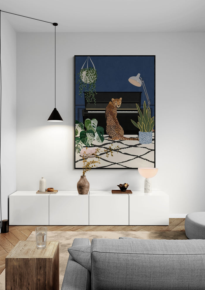 Framed print of "Cheetah playing piano - Sarah Manovski" hanging in a modern living room above white cabinet.
