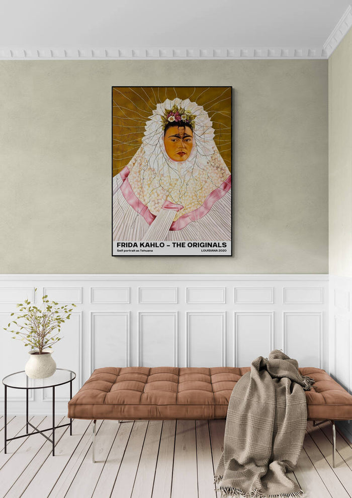 Frida Kahlo as Tehuana art print hanging on a pale green wall above a cushioned bench in a stylish room.