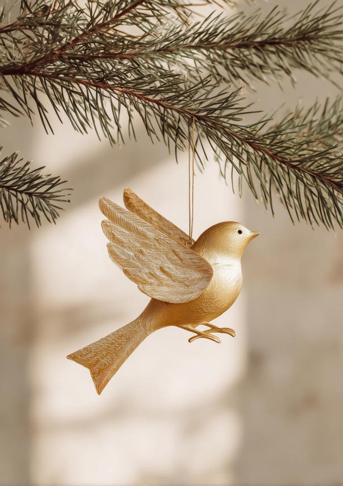Golden Bird ornament hanging from a pine branch, featuring detailed wings and a smooth golden finish.