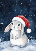 Cute gray bunny wearing a Santa hat sits in the snow with snowflakes falling, perfect for Home for the Holidays.