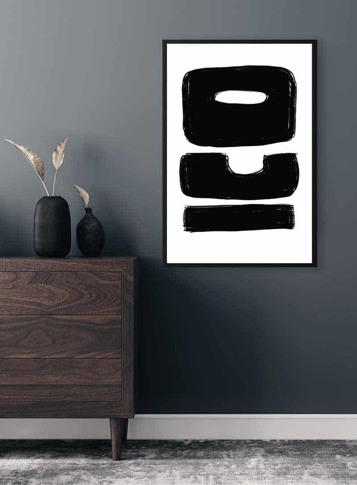 ICO Unique Plakat featuring bold black abstract lettering, framed and hung above a modern wooden dresser.