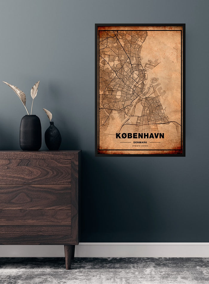 Kort over København poster featuring a vintage-style map of Copenhagen, framed and hung on a dark wall.