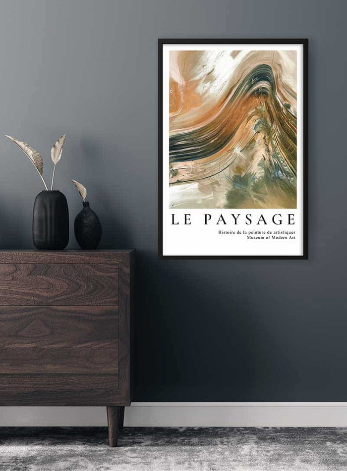 Framed abstract painting poster "Le Paysage" displayed on a dark wall above a wooden dresser.