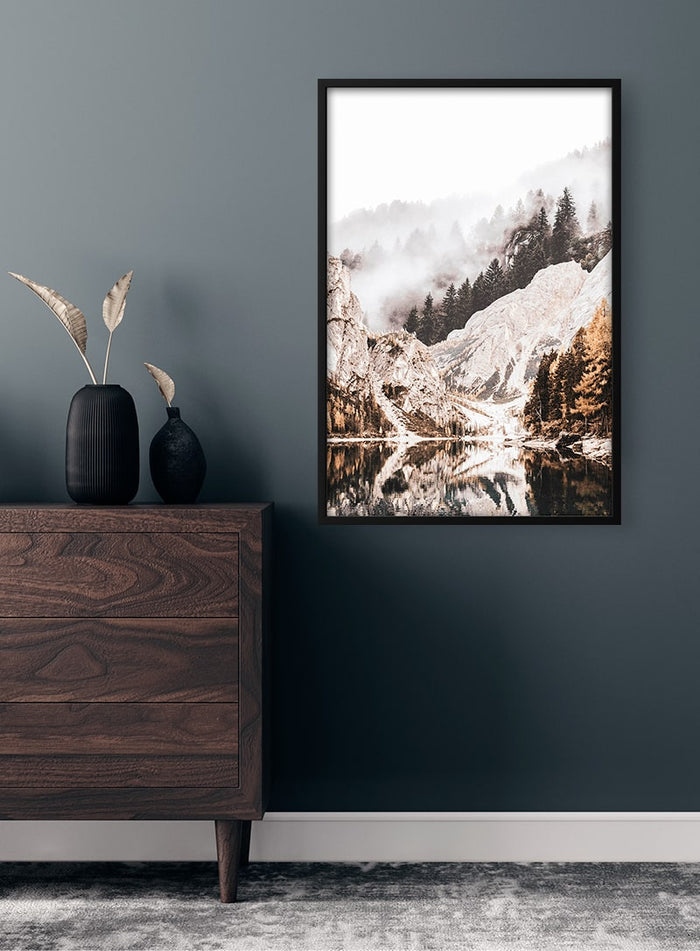 Framed Mountainlake Plakat featuring a serene lake, snow-covered mountains, and pine trees on a modern wall.