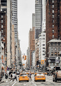 Yellow taxis and busy street scene surrounded by tall buildings in New York City.