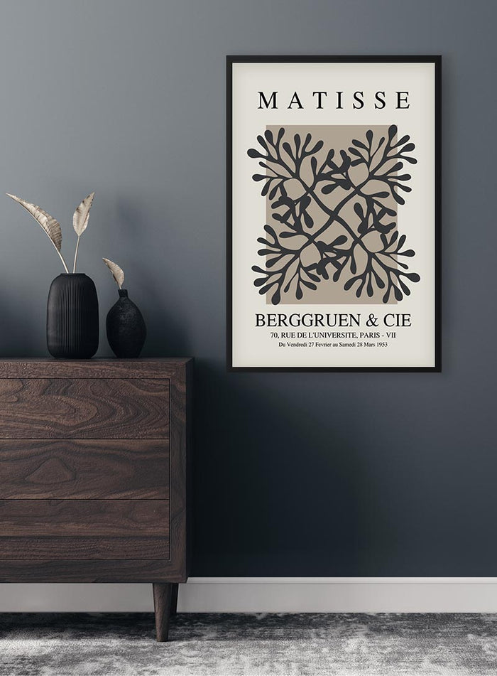 Papier Decoupe Coral Flower Plakat framed on a dark wall above a modern wooden dresser with decorative vases.