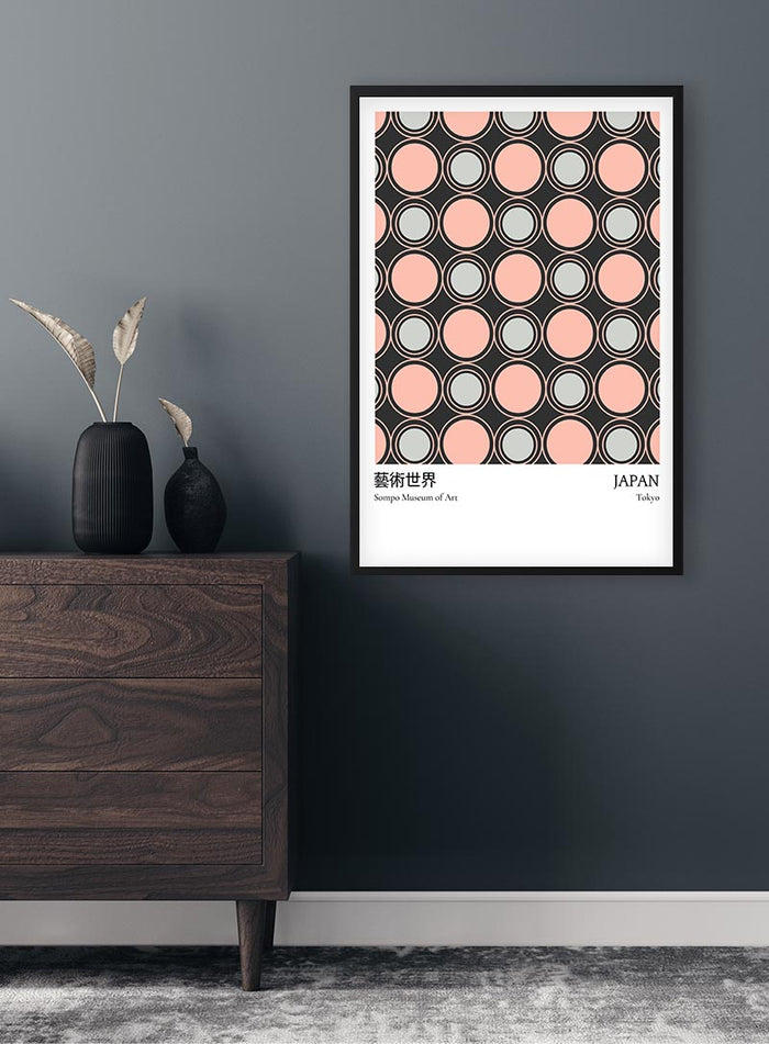 Framed Pink Dots From Japan Exhibition Plakat on a gray wall above a wooden dresser with decorative vases.