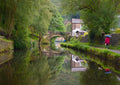 Red Coat on the Towpath by Northern Gnome Photography - a woman in red beside a still canal with a stone bridge