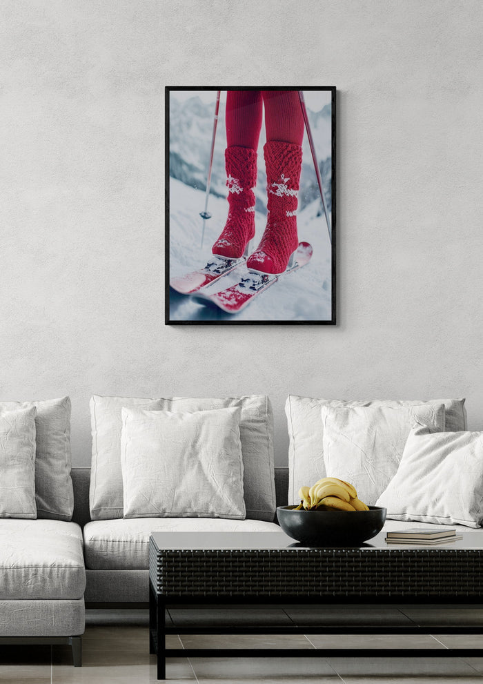 Framed photo of red ski boots and skis in the snow, displayed above a modern white sofa in a living room.