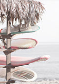 Four surfboards stacked under a thatched roof by the beach, displayed on Surfboards on Beach Plakat.