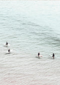 Four surfers on surfboards sit in calm, pale water seen from above for Surfers in Water Plakat.