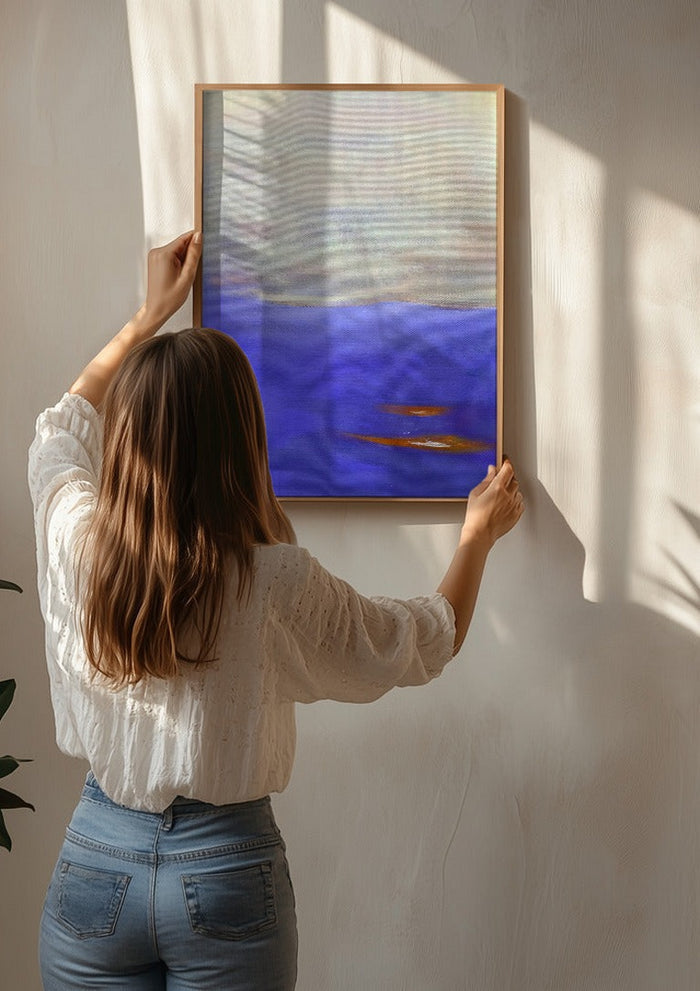 Violet Sea by Marina Agre being hung on a sunlit wall