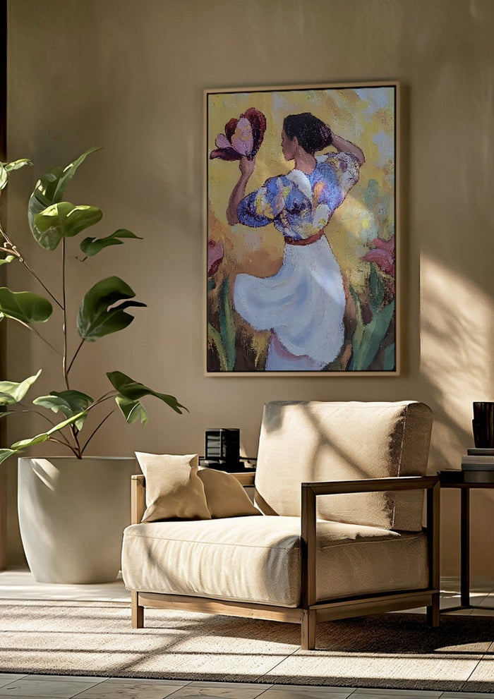 Woman with a Tulip by Elena Avanesova framed above a beige armchair beside a potted plant